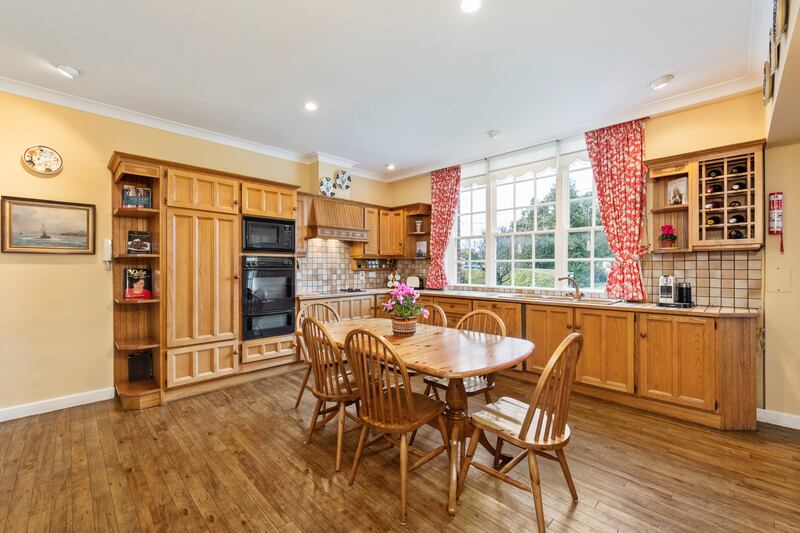 To the left off the hall is a wide kitchen with wooden units and a large window looking out to the front garden.