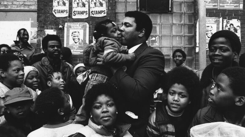 Ali kisses a child while campaigning for Harold Washington in Chicago, 1983. Photo: Getty Images