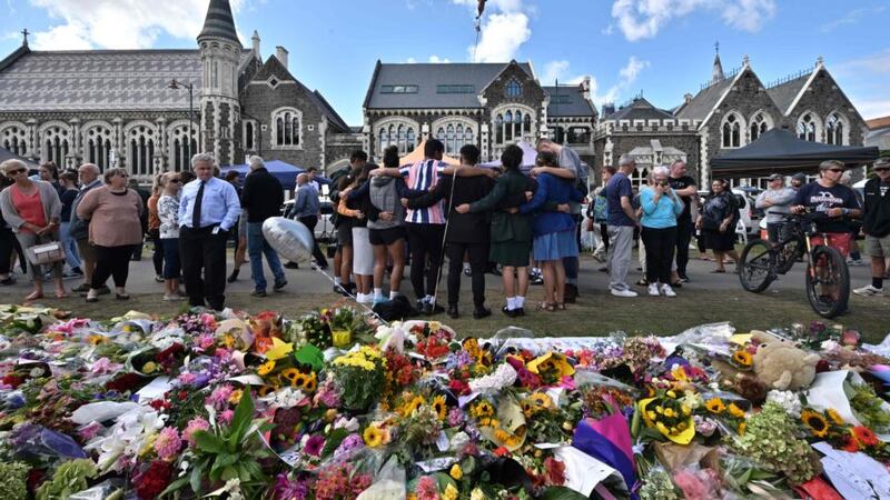 A group of students (centre) sings in front of flowers left in tribute to victims at the Botanical Garden in Christchurch on March 19, 2019, four days after a shooting incident at two mosques in the city  claimed the lives of 50 people. Photograph: Anthony Wallace/AFP/Getty