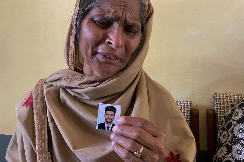 Tazeem Pervaiz, mother of Taquir Pervaiz, who is missing since an overcrowded trawler capsized in the Mediterranean Sea last week, weeps while holding a picture of her son in Bandli village. Photograph: Sajjad Qayyum/AFP via Getty Images