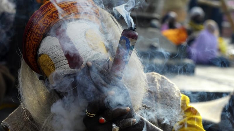 A Nepalese Sadhu or Hindu holy man smokes marijuana using a “chillum”, a traditional clay pipe, as a holy offering for Lord Shiva, the Hindu god of creation and destruction. Photograph: Prakash Mathema/AFP/Getty Images