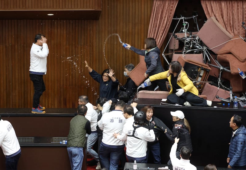 Lawmakers of Democratic Progressive Party (DPP) throw water to lawmakers of opposition party Kuomintang (KMT) after the DPP occupied the night to avoid the passing of the third reading of amendments to the Civil Servants Election and Recall Act and other controversial bills at the Legislative Yuan in Taipei. Photograph: I-Hwa Cheng/AFP