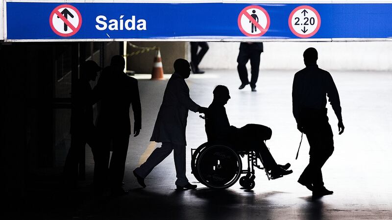 OCI president Pat Hickey is escorted from the  Samaritano Hospital in Sao Paulo after treatment following his arrest. Photograph: Dan Sheridan/Inpho