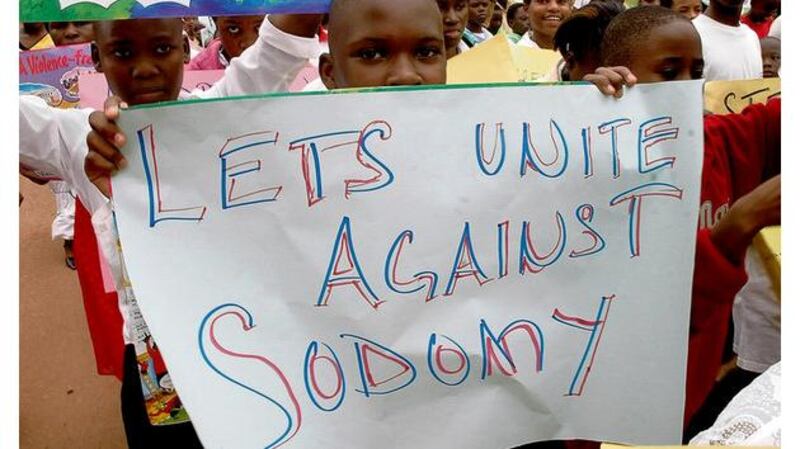 Children hold anti-gay signs at an organised demonstration of thousands of Ugandans against homosexuality the capital city, Kampala, last week.