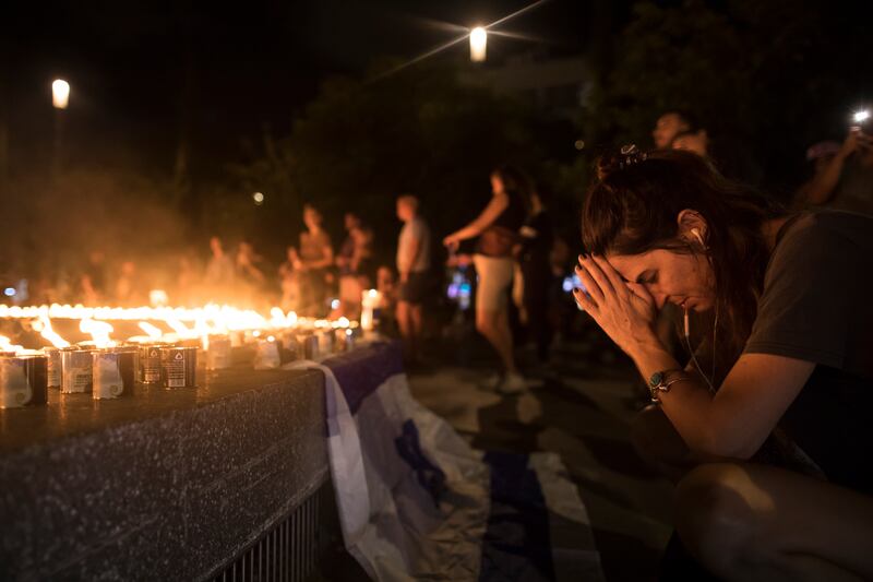 A woman pays tribute in Dizingof Square in Tel Aviv as people light candles in memory of the civilians and soldiers killed, and for the hostages that were taken to the Gaza Strip. Photograph: Amir Levy/Getty Images