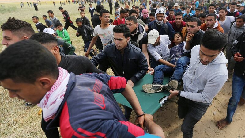 A wounded Palestinian is evacuated during clashes with Israeli troops during a tent city protest along the Israel border with Gaza. Photograph: Ibraheem Abu Mustafa/Reuters