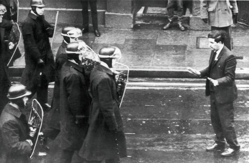 A squad of helmeted riot police with shields move in to break up a mob of demonstrators, civil rights leader John Hume, a member of the Ulster Parliament is seen here stepping into their path pleading with them not to use violence in the centre of Derry. 21st April 1969 
Photograph: Daily Mirror/Mirrorpix via Getty Images