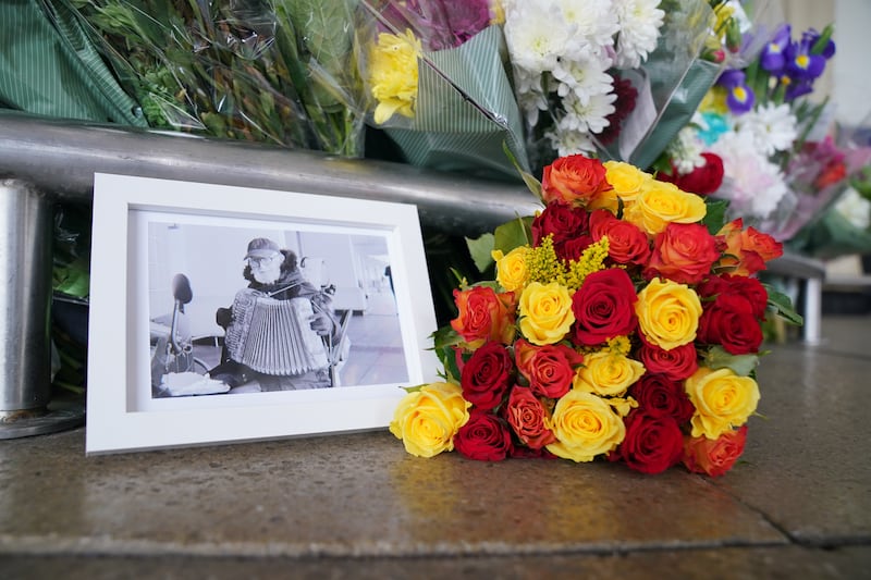 A picture of Thomas O'Halloran left amongst floral tributes outside Perivale Tesco, Greenford, in 2022, where he used to play his accordion. Photograph: PA