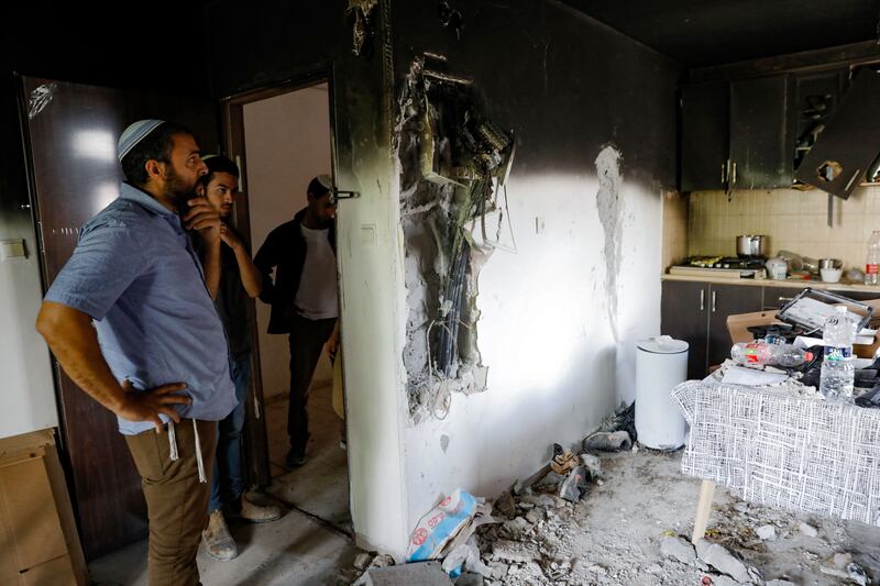 Israelis stand in the midst of scattered objects in a house that was damaged by fire during  intra-communal violence between Arab and Jewish Israelis in the Israeli Arab city of Lod near Tel Aviv, on May 23rd 2021. Photograph: Gil Cohen-Magen/AFP via Getty Images