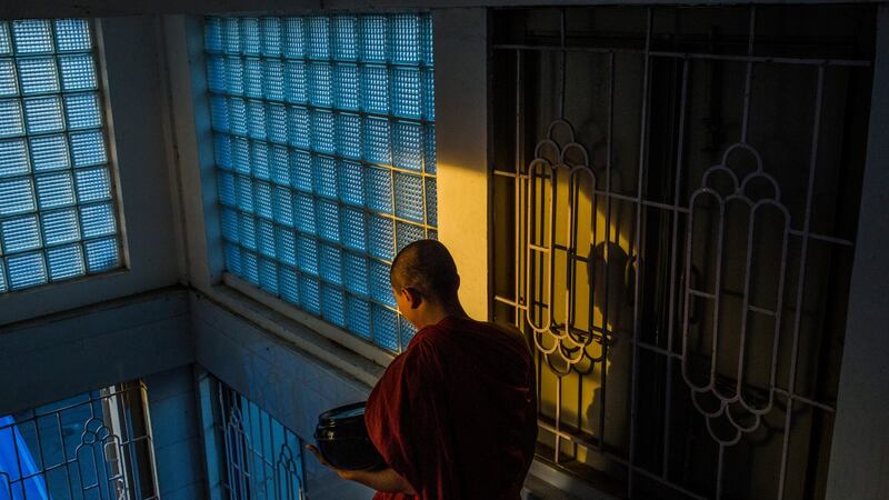 A Buddhist monk leaves the New Masoeyein monastery to collect alms, in Mandalay, Myanmar. Photograph: Minzayar Oo/The New York Times