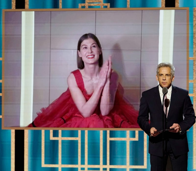 I Care a Lot: Rosamund Pike accepts her Golden Globe as Ben Stiller speaks onstage on Sunday night. Photograph: Peter Kramer/NBCUniversal via AFP