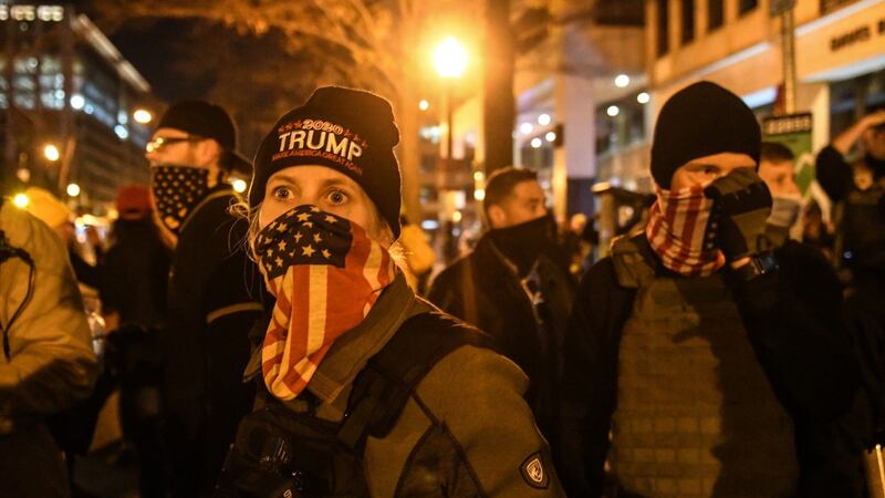 A woman with the Proud Boys wears an American flag bandana during a protest on December Saturday in Washington DC.  Photograph: Stephanie Keith/Getty Images