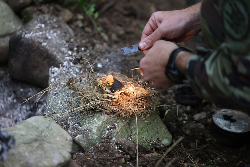 Participants learn how to light a fire using minimum equipment in a survival scenario. Photograph: Dara Mac Dónaill






