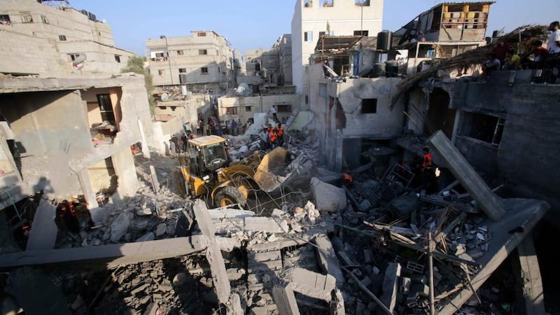 Searching: rescue workers look through the rubble of a house in Khan Younis, in the southern Gaza Strip, destroyed in an air strike. Photograph: Ibraheem Abu Mustafa/Reuters