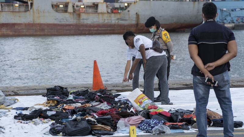 Search and rescue team members look at debris recovered from the crash site on the dockside at Tanjung Priok Port in Jakarta, Indonesia. Photograph: Rony Zakaria/Bloomberg