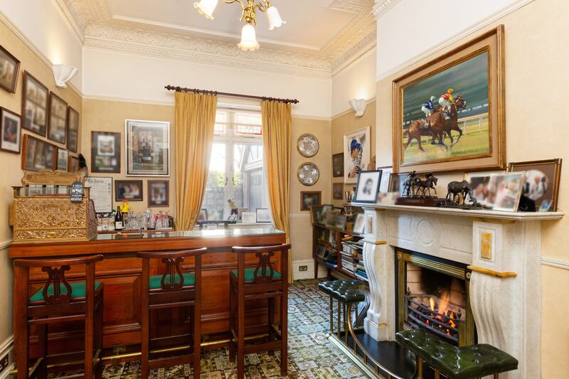 A small reception room is fitted out as a bar, complete with brass cash register.