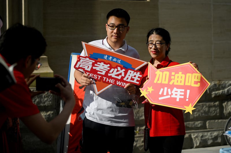 Students pose holding a poster reading 'Gao Kao, must win' before entering a school on the first day of China's National College Entrance Examination in Beijing. Photograph: Wang Zhao/AFP via Getty Images