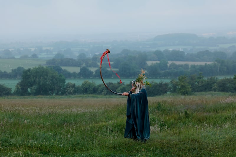 A visitor to the Hill of Tara, from Armagh, with a replica of the Loughnashade trumpet at sunrise on the Summer Solstice. Photograph: Alan Betson/The Irish Times

