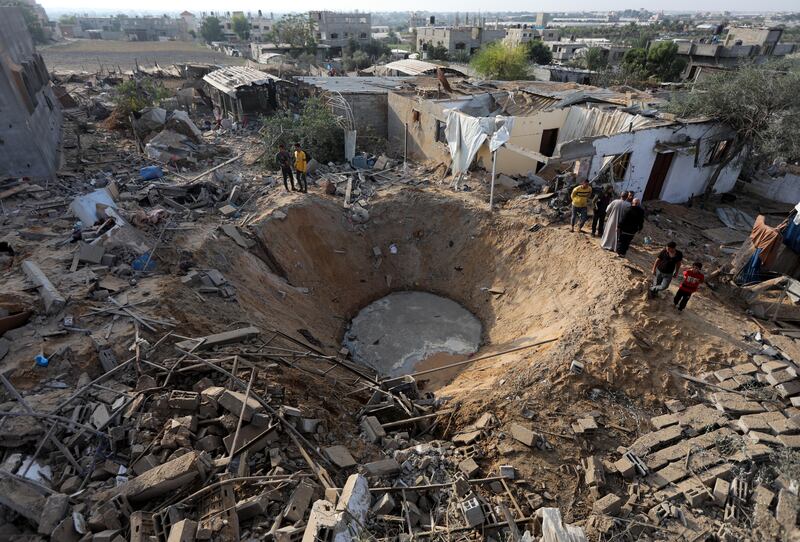 People gather around a bomb crater left by an Israeli air strike in Khan Younis in Gaza on Wednesday. Photograph: Yousef Masoud/The New York Times
                      