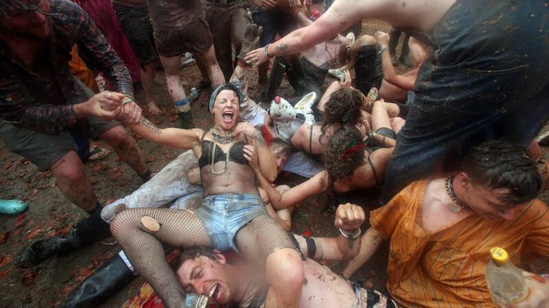 People take part in a tomato fight at the Common at the Glastonbury Festival. Photo by Matt Cardy/Getty Images.