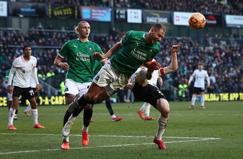 Plymouth's Bosnian defender Nikola Katic dives to head the ball clear from the foot of Liverpool's Portuguese striker Diogo Jota. Photograph: Henry Nicholls/AFP via Getty Images