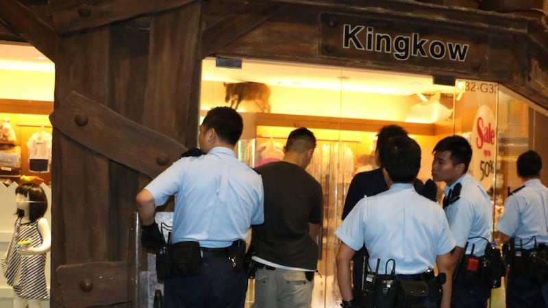 Police officers watch a wild boar at a children’s clothing store at a mall in Hong Kong. Photograph: AP/Apple Daily.