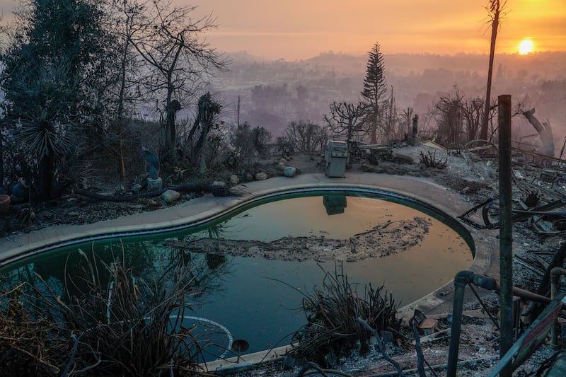 The sun sets over destroyed homes during the Palisades fire last week. Photograph: Kyle Grillot/The New York Times
                      