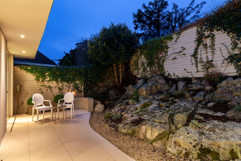 A rocky granite outcrop frames the rear outdoor space