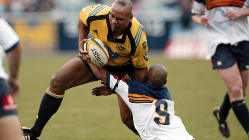 Jonah Lomu in action as George Gregan holds onto him  during the Brumbies against the Hurricanes match in Canbarra, Australia, on  April 14th, 2002. Photograph: EPA