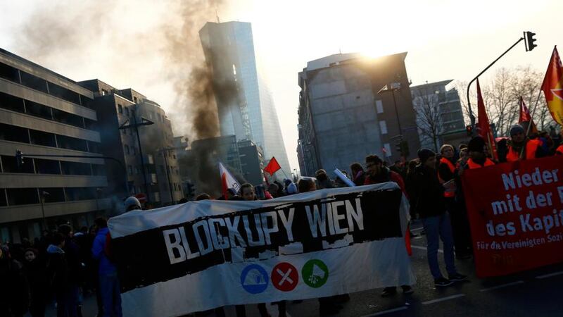 Anti-capitalist ‘Blockupy’ protesters hold banners near the European Central Bank (ECB) building (seen in the background). Photograph: Kai Pfaffenbach/Reuters