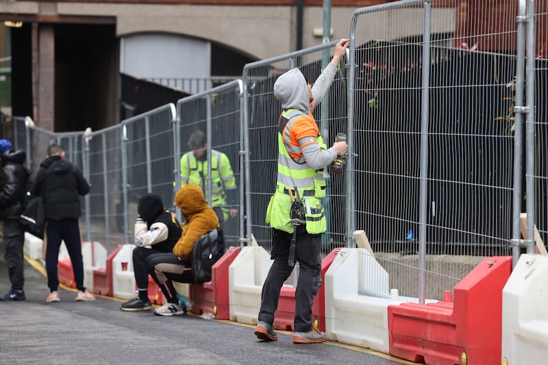 Workers continue to secure the fencing around International Protection Office and surrounds on Mount Street, Dublin to stop tents being pitched. Photograph: Dara Mac Dónaill
