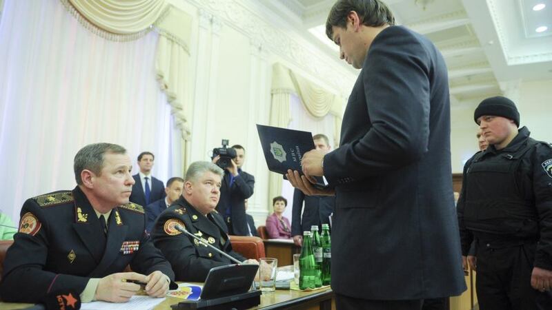 A handout picture taken and released by the Ukrainian prime minister’s press service in Kiev on Wednesday shows a policeman reading their arrest warrant to Sergiy Bochkovsky (second from left), director of Ukraine’s emergency services ministry, and his deputy Vasyl Stoyetsky. The two Ukrainian officials were arrested  on corruption charges and led away in handcuffs from a televised cabinet meeting as government ministers looked on. Photograph: Andrew Kravchenko/AFP/Getty Images