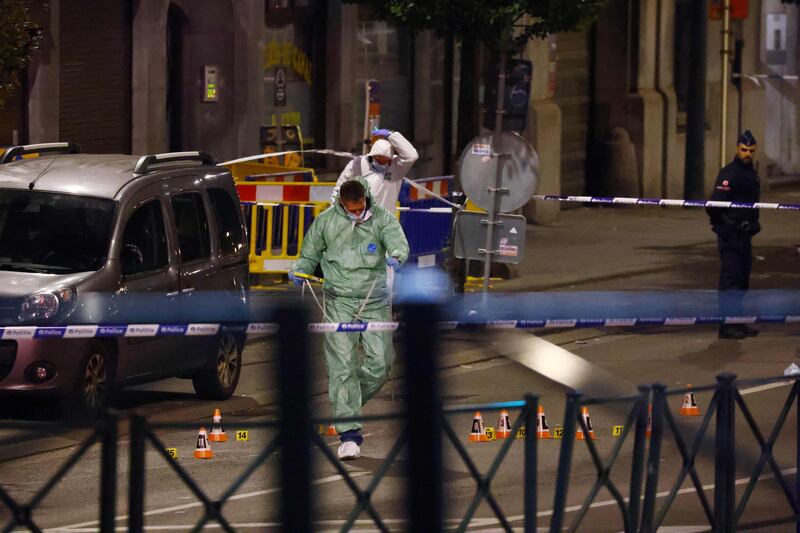 Belgian police officers from the forensic service search for evidence in a street after two people were shot dead in Brussels by a suspect who is on the run. Photograph: Kenzo Tribouillard/AFP via Getty Images