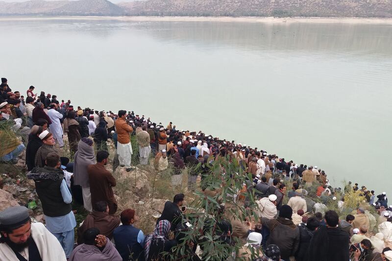 Onlookers gather beside the Tanda Dam after a boat carrying students capsized in the Kohat district of northern Khyber Pakhtunkhwa. Photograph: Basit Shah/Getty Images