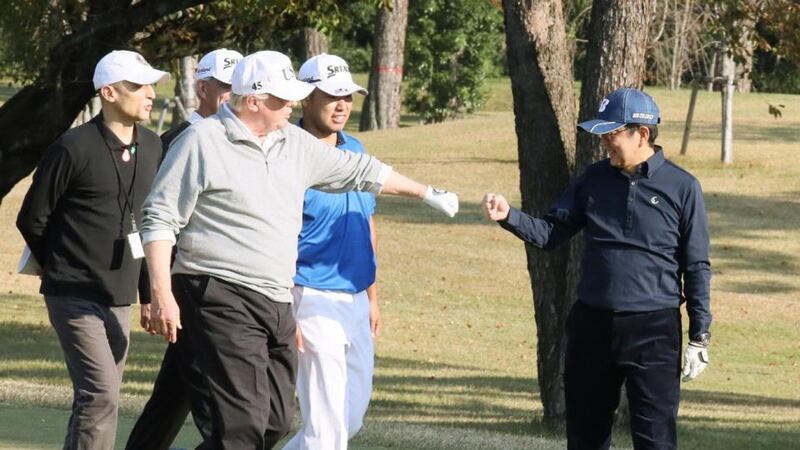 Fist bumps: Donald Trump and Japanese prime minister Shinzo Abe (with Hideki Matsuyama, second right) on the golf course. Photograph: Japanese government via Jiji Press/AFP/Getty