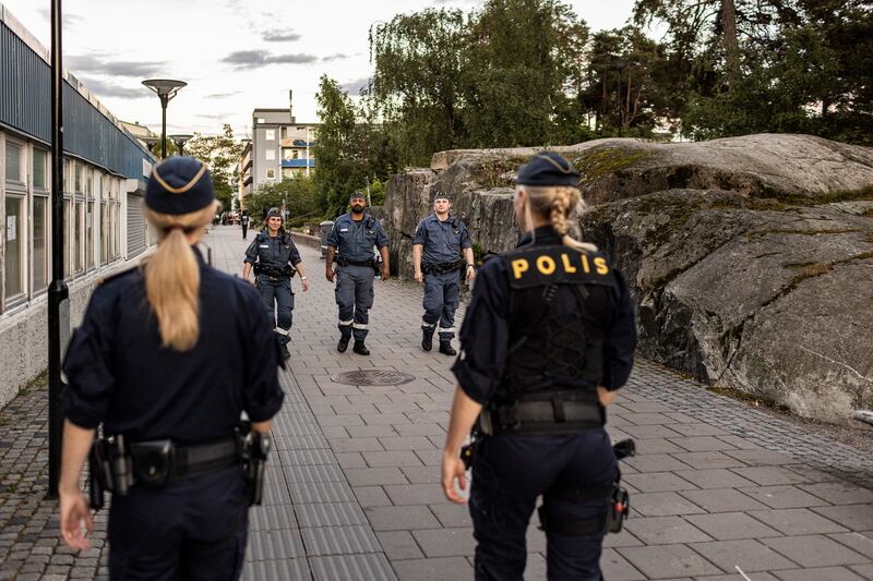 Officers and security guards patrol the Rinkeby neighborhood of Stockholm. Photograph: Ilvy Njiokiktjien/The New York Times