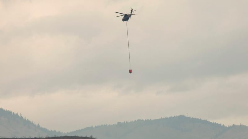 A helicopter carrying water flies toward the Carlton Complex Fire near Methow, Washington. Photograph: David Ryder/Reuters.