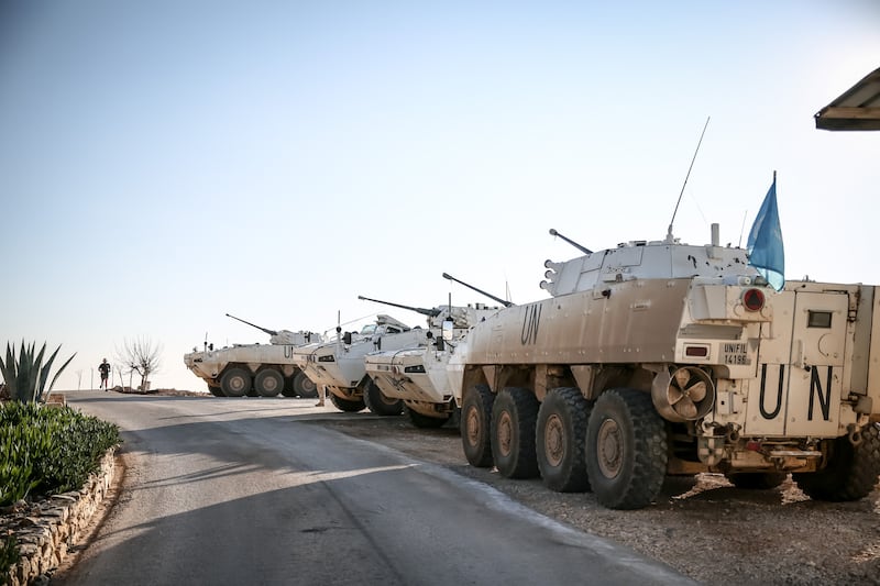 A peacekeeper jogs past Unifil vehicles inside Camp Shamrock. Photograph: Sally Hayden