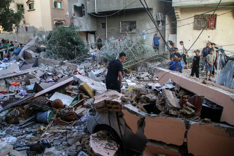 Palestinian emergency services and local citizens search for victims in buildings destroyed during Israeli air raids in the southern Gaza Strip, in Khan Yunis. Photograph: Ahmad Hasaballah/Getty