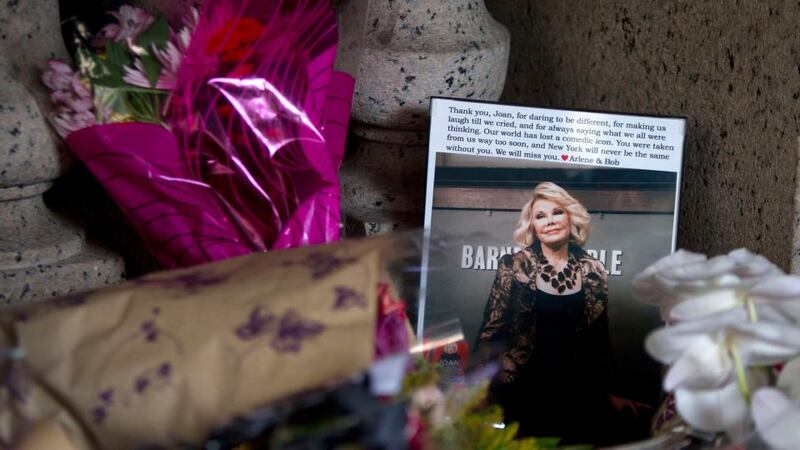 Flowers and a photo, which were left in tribute as part of a makeshift memorial, sit on the steps in front of Joan Rivers’ home in  Manhattan. Photograph: Reuters