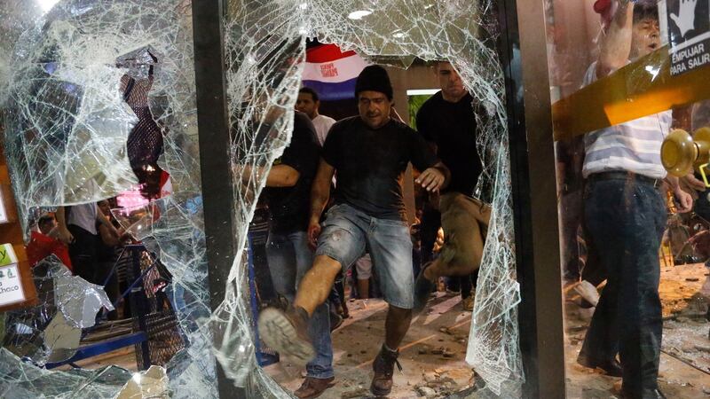 A man breaks a window of the Congress building during a protest against presidential re-elections, in Asuncion, Paraguay on Friday. Photograph: Jorge Saenz/AP