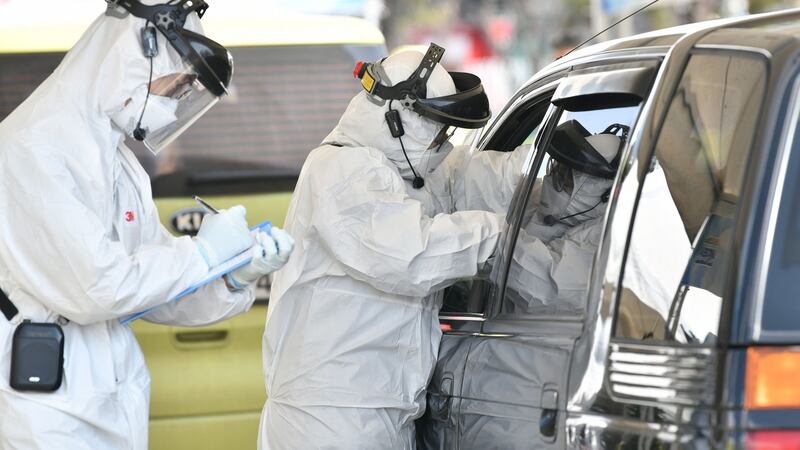 Medical staff wearing protective gear take samples from a driver with suspected symptoms of the Covid-19 coronavirus, at a “drive-through” virus test facility in Goyang, north of Seoul. Phottograph: JUNG YEON-JE/AFP/Getty Images