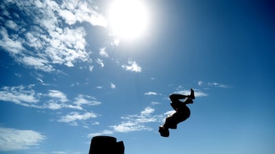 Teens jump off the jetty at Glenelg beach during a hot day in Adelaide. Photograph: Kelly Barnes/EPA