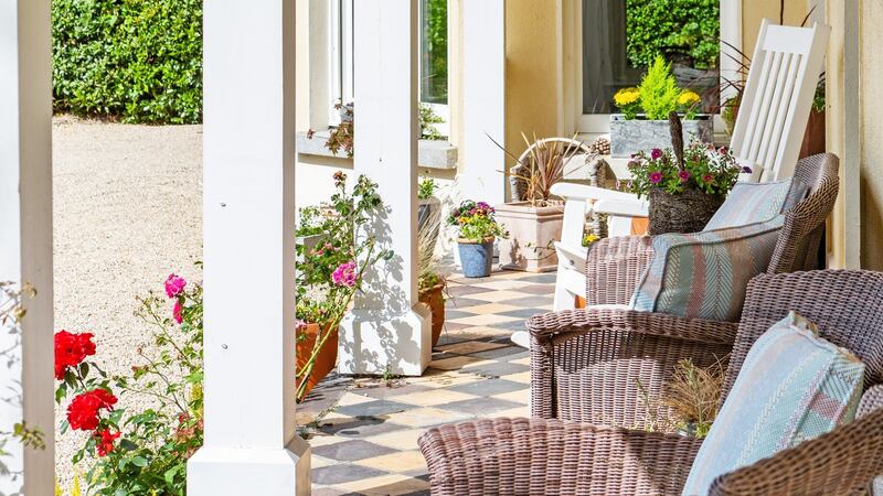 Verandah: Wicker chairs on the black-and-white tiled outdoor space