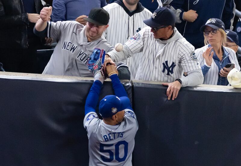 Fans Austin Capobianco (L) and John Peter (R) interfere with Mookie Betts of the Los Angeles Dodgers as he attempts to catch a fly ball in foul territory during the first inning of game four of the 2024 World Series against the New York Yankees. Photograph: Al Bello/Getty Images