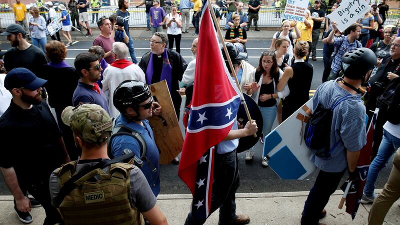 A white supremacist carries the Confederate flag as he walks past counter-demonstrators in Charlottesville, Virginia, US. Photograph: Joshua Roberts/Reuters