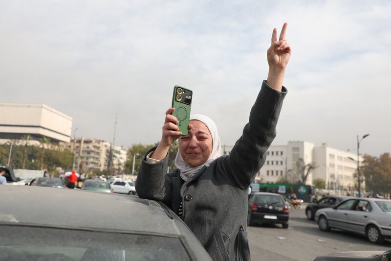 People celebrate the fall of the Syrian regime in Umayyad Square. Photograph: Ali Haj Suleiman/Getty Images