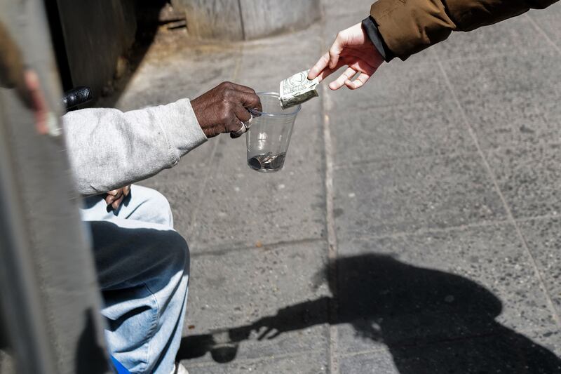 A homeless man receives a dollar bill in Manhattan. Photograph: Charly Triballeau/AFP via Getty Images