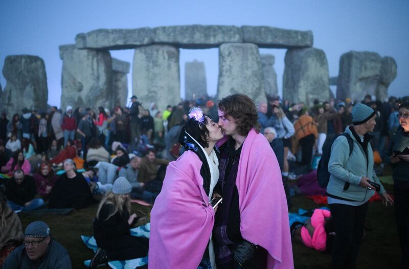 Two revellers embrace by Stonehenge. Photograph: Daniel Leal/AFP via Getty