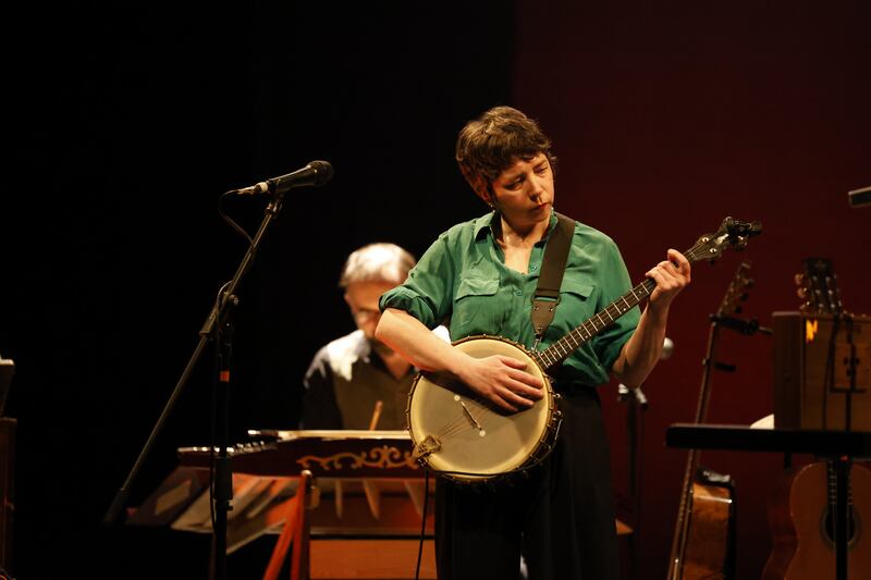 Lisa O'Neill moves between banjo and guitar on stage at the Gate 